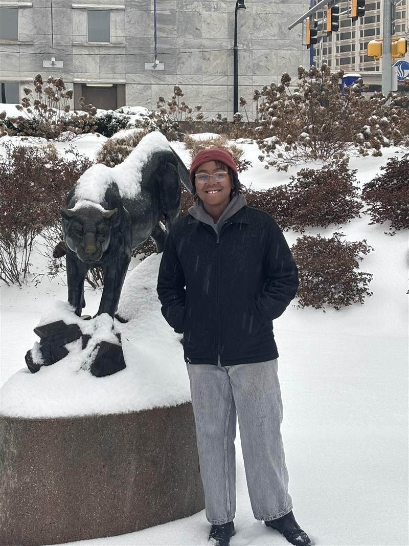 An image of Morgan Guinyard. She is standing in front of a snow-covered panther statue on Georgia State University's campus.